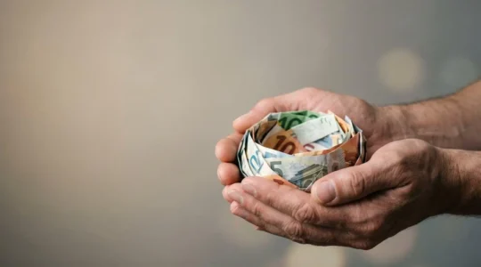 Main tenant un livret d'épargne avec symbole de protection financière et croissance